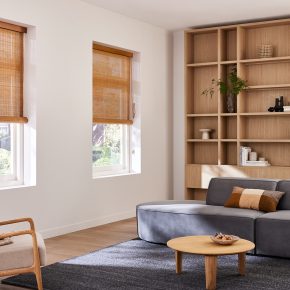 Bruinhouten Woodweave blinds in een landelijke woonkamer met grijsblauwe bank en een houten kast
