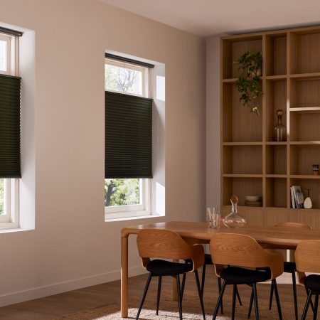 Zwarte Plisse shades in een landelijke woonkamer met tafel en stoelen